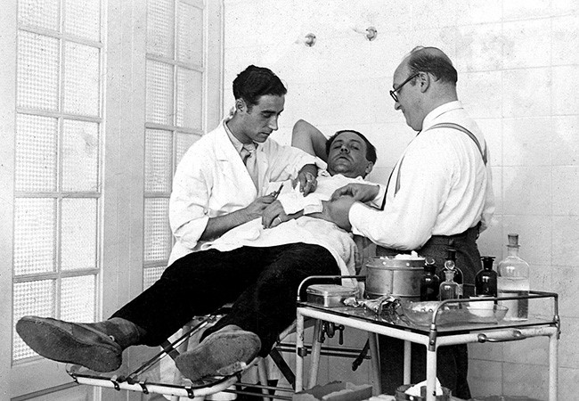 El doctor Fabrés atenent un treballador de la fàbrica Roca de Gavà. Anys 1930. [Arxiu Municipal de Gavà]