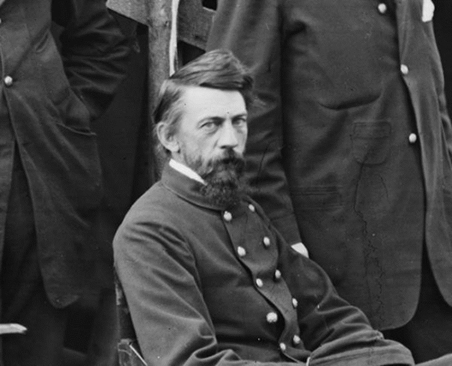 Assegut davant la seva tenda, amb uns companys militars.