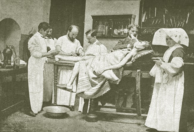 Salvador Cardenal, tercer a l'esquerra, procedint una operació quirúrgica. Marià de Vilar és el darrer a la dreta, al costat d'una monja infermera.  Sala de l'Hospital del Sagrat Cor, 1884. [Cardenal, S. Manual práctico de Cirugía Antiséptica. 1894, p. 393]