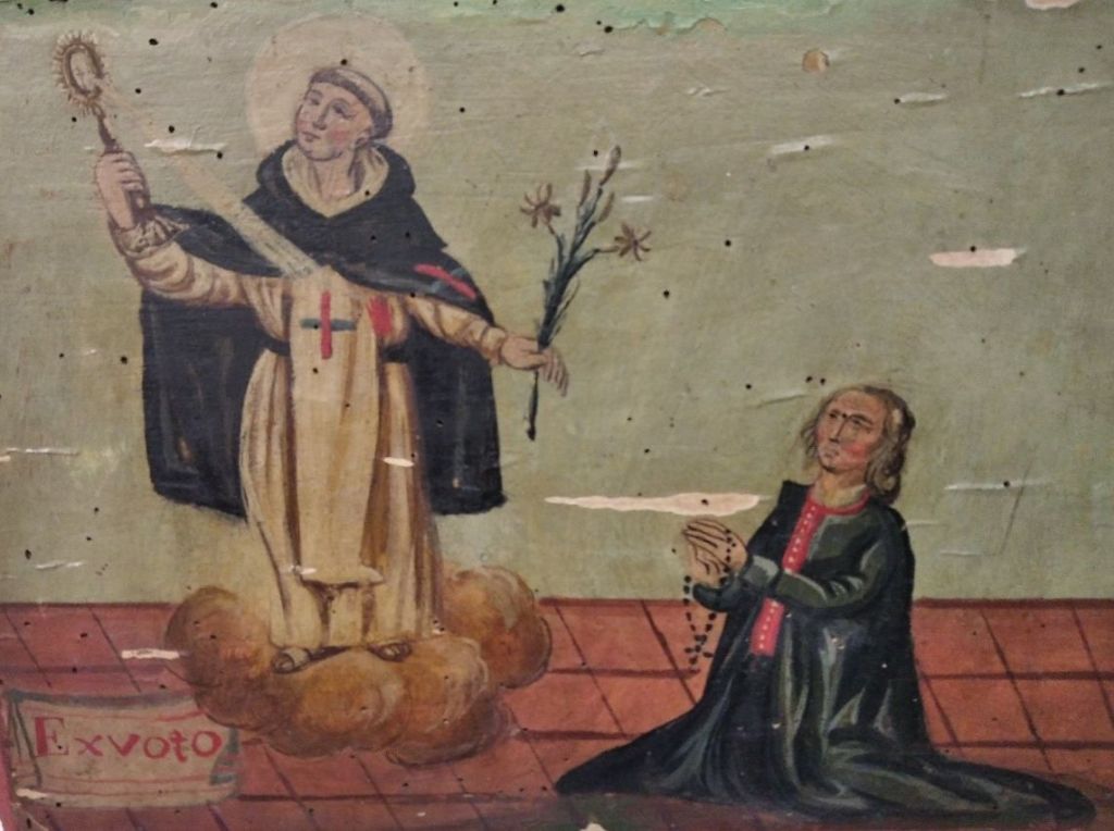 Un orant baró, mudat per l'època, pregant a Sant Miquel. Aquesta imatge ens permet apreciar els atributs del sant: l'hàbit de frare trinitari, el calze (a la mà dreta) i el lliri (a la mà esquerra)